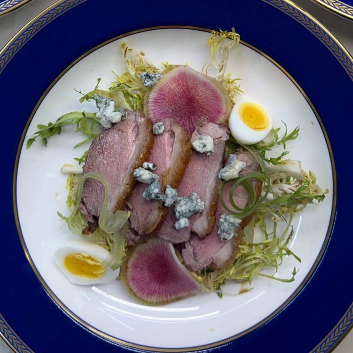 Seared duck breast salad with frisée, watermelon radish, quail egg and blue cheese
