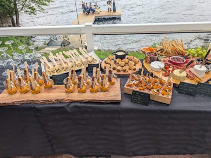 Lakeside event table set with canapés and grazing boards