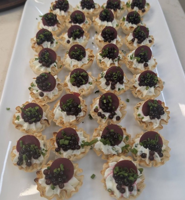 Tray of filo canapé cups topped with beetroot and caviar