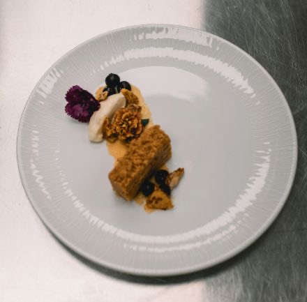 Spiced cake dessert with mousse and edible flowers